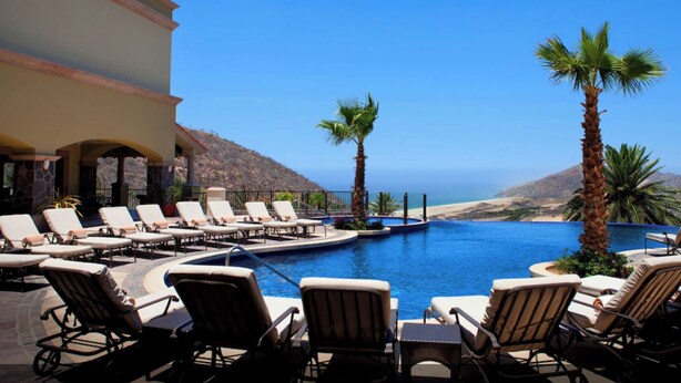 A poolside area with lounge chairs and a view of the ocean. - MONTECRISTO Charming 3-bedroom villa with AC in marvelous Cabo San Lucas (Cabo San Lucas)