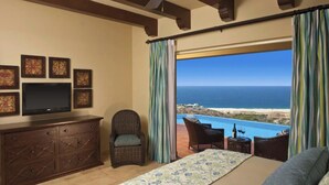 A bedroom with a large window overlooking a beach and ocean, a television, a dresser, and a chair. - MONTECRISTO Charming 3-bedroom villa with AC in marvelous Cabo San Lucas (Cabo San Lucas)