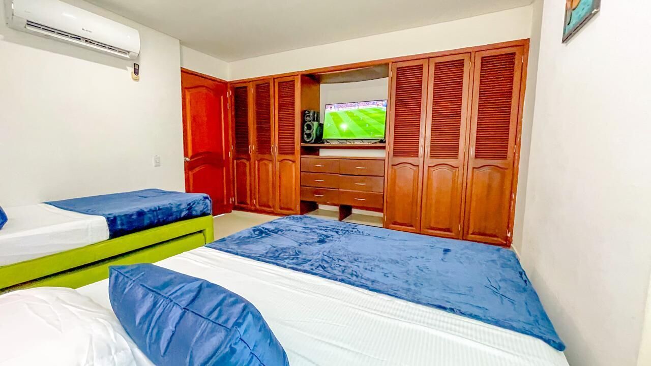 A room with two beds, a TV, and a wardrobe.