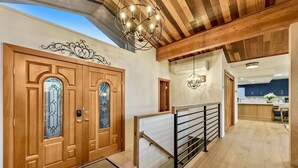 A modern interior with wooden doors, a staircase, and a kitchen area.