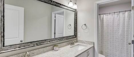 Un baño con dos lavamanos, un espejo grande y una cortina de ducha.