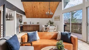Uma sala de estar moderna com teto de madeira, um sofá e uma mesa de centro.