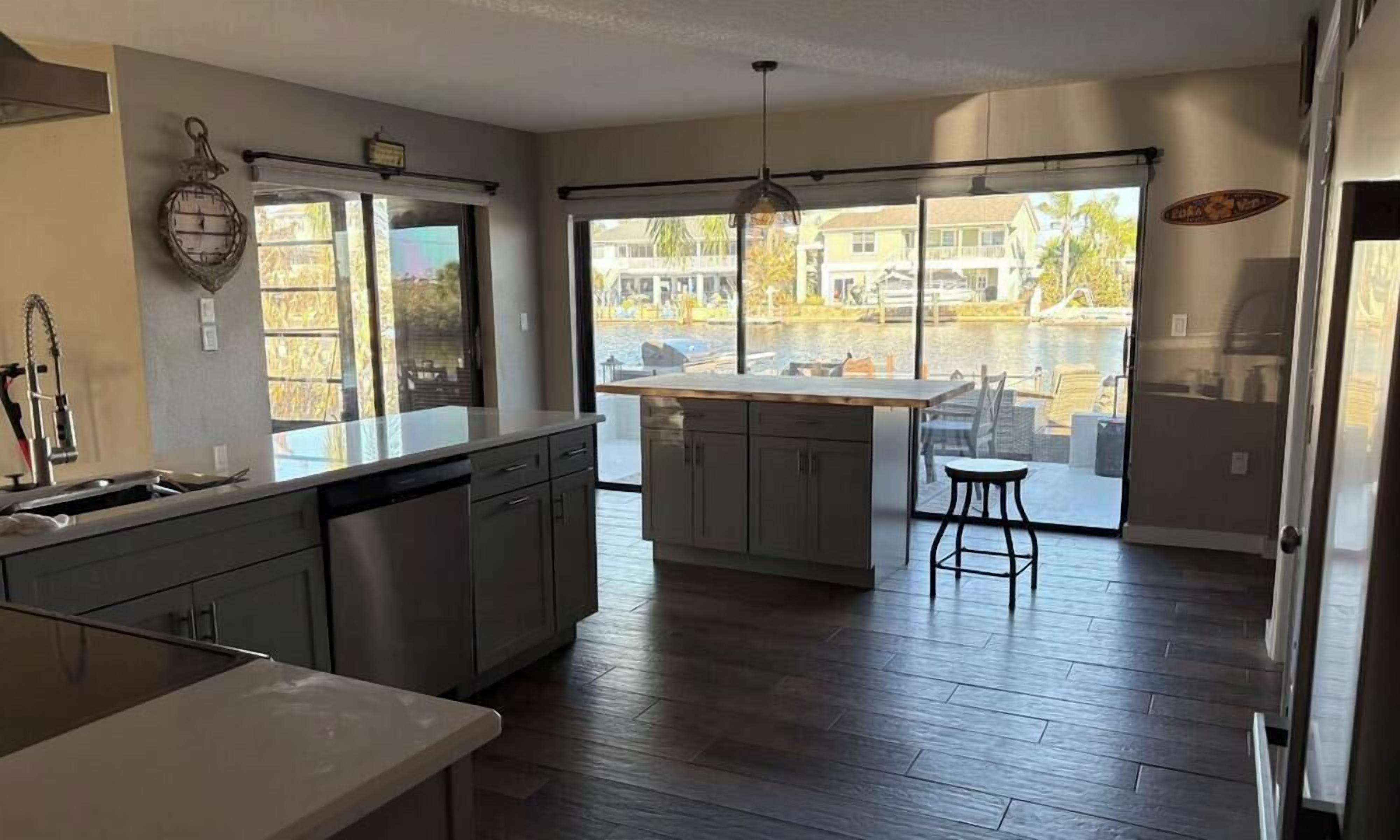 Una cocina moderna con una isla grande, un comedor con vistas y un amplio salón con un ventanal.