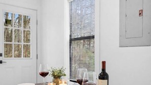 A dining area with a wooden table set for two, white plates, wine glasses, and a candle. - Minutes From UNC - 15 Min to Duke - Private Deck (Chapel Hill)