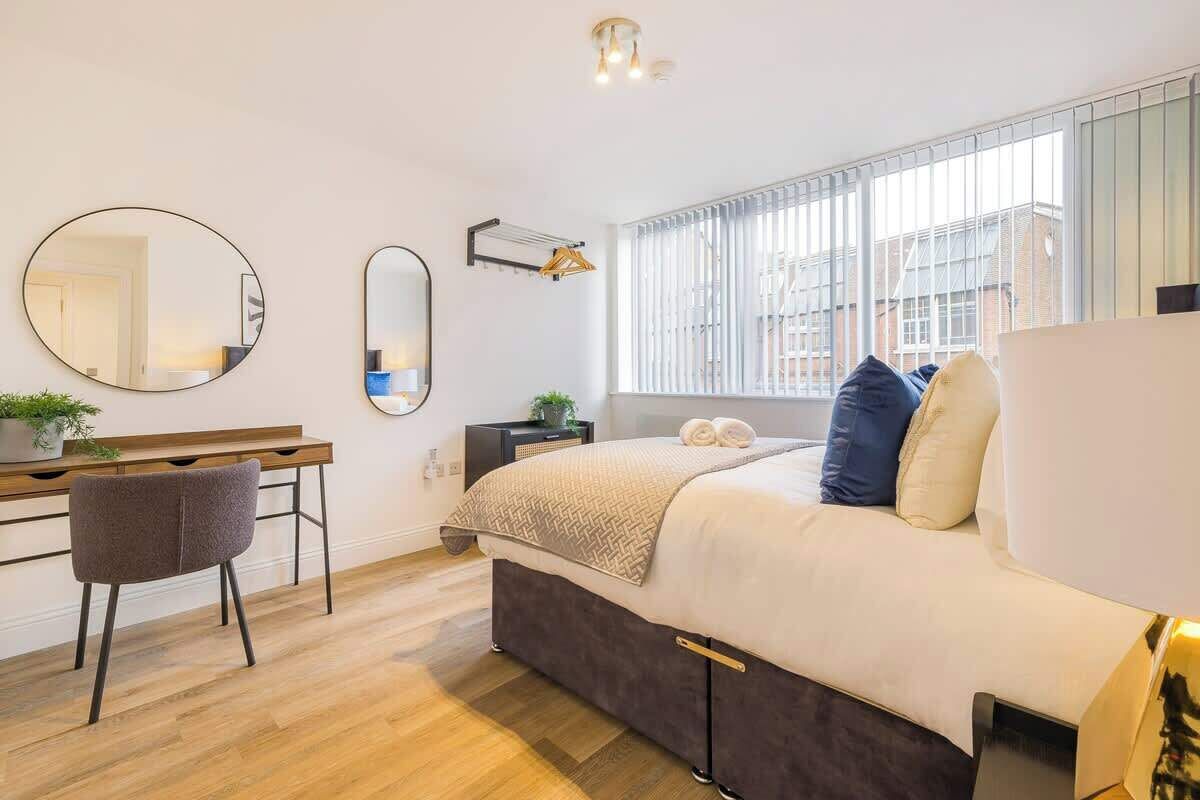 Une chambre moderne avec un lit, un bureau, une chaise et une grande fenêtre.