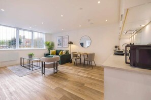 Ein modernes Wohnzimmer mit Sofa, Couchtisch und Essbereich.