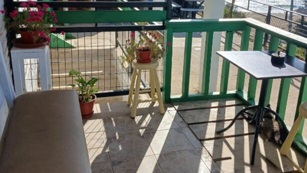 A covered outdoor seating area with a bench, a table, and potted plants. - House in el quisco (El Quisco)