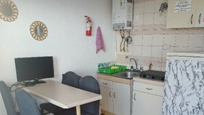 A compact kitchen with a dining table, chairs, a stove, and a refrigerator. - House in el quisco (El Quisco)