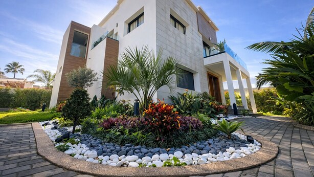A modern two-story house with a landscaped garden in front. - Private 3-Story Villa with Pool, Garden & Garage Parking (Mohammedia)