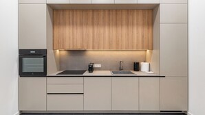 A modern kitchen with a built-in oven, a coffee machine, and a sink. - Vytauto 43 Residence – Lietūkis by Domvia (Kaunas)