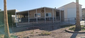 A single-story house with a covered porch, a fenced yard, and a satellite dish on the roof. - Hit the Trail or Lake: Spacious 4BR/2BA Retreat with Pool Table & Large Bar Area (Needles)