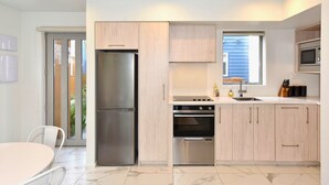 Eine moderne Küche mit einem Edelstahl-Kühlschrank, einem eingebauten Backofen und einer Mikrowelle.