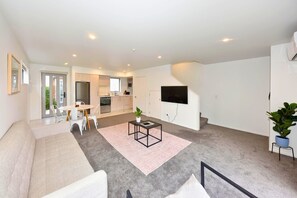 A modern living room with a sofa, coffee table, and TV.