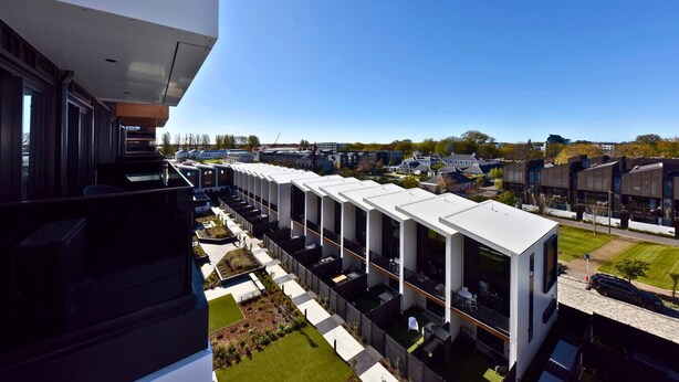 Un edificio moderno con una serie di balconi e una vista aperta sulla zona circostante.