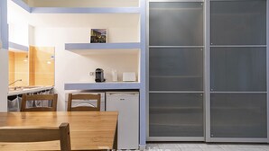 Eine kleine Küche mit einem Holztisch, einer Spüle und einem kleinen Kühlschrank.