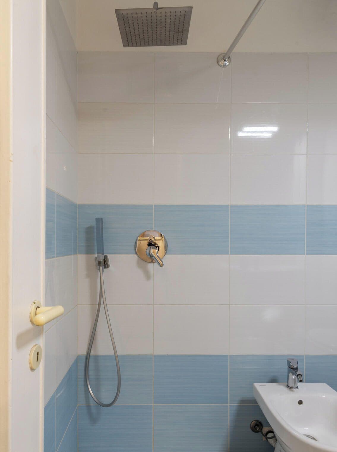 A bathroom with a shower, a sink, and a toilet.