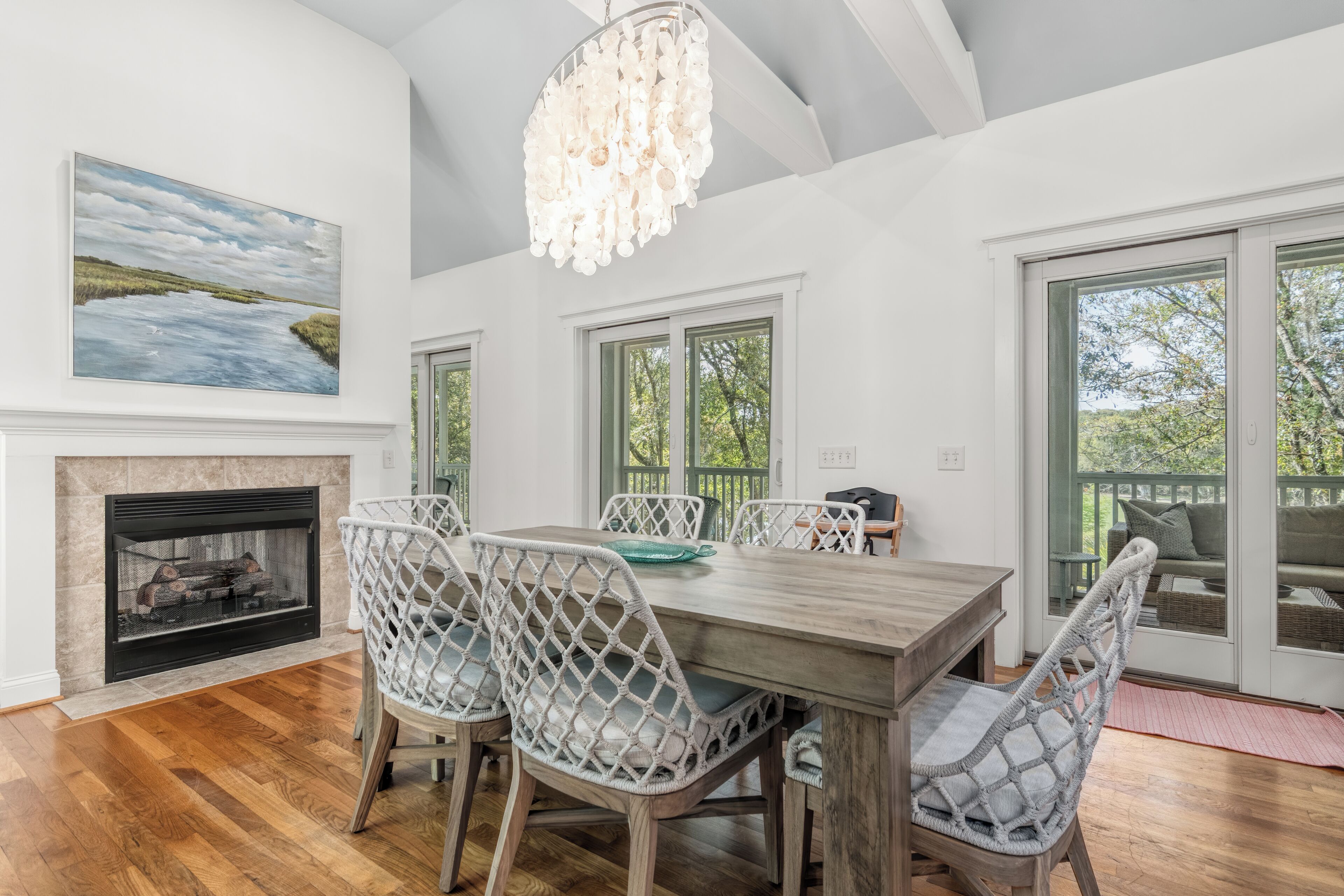 A dining area with a fireplace, wooden dining table, and chairs.