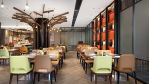 Un restaurant moderne avec un long comptoir, de nombreuses tables et des chaises.