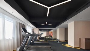 Une salle de sport moderne équipée de tapis de course, d’haltères et de poids.