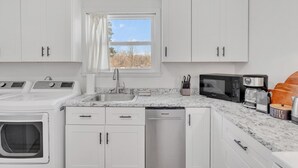 A modern kitchen with white cabinetry, a stainless steel sink, a built-in dishwasher, a microwave, and a coffee maker. - 5Min to Downtown Franklin/Pet Friendly/Fenced Yard (Franklin)