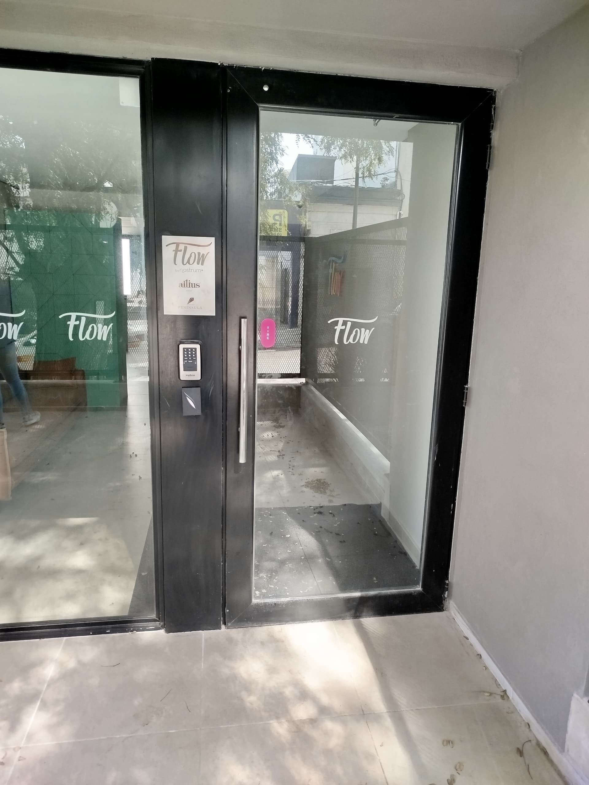 A glass door with a sign reading "Flow" and a keypad lock.