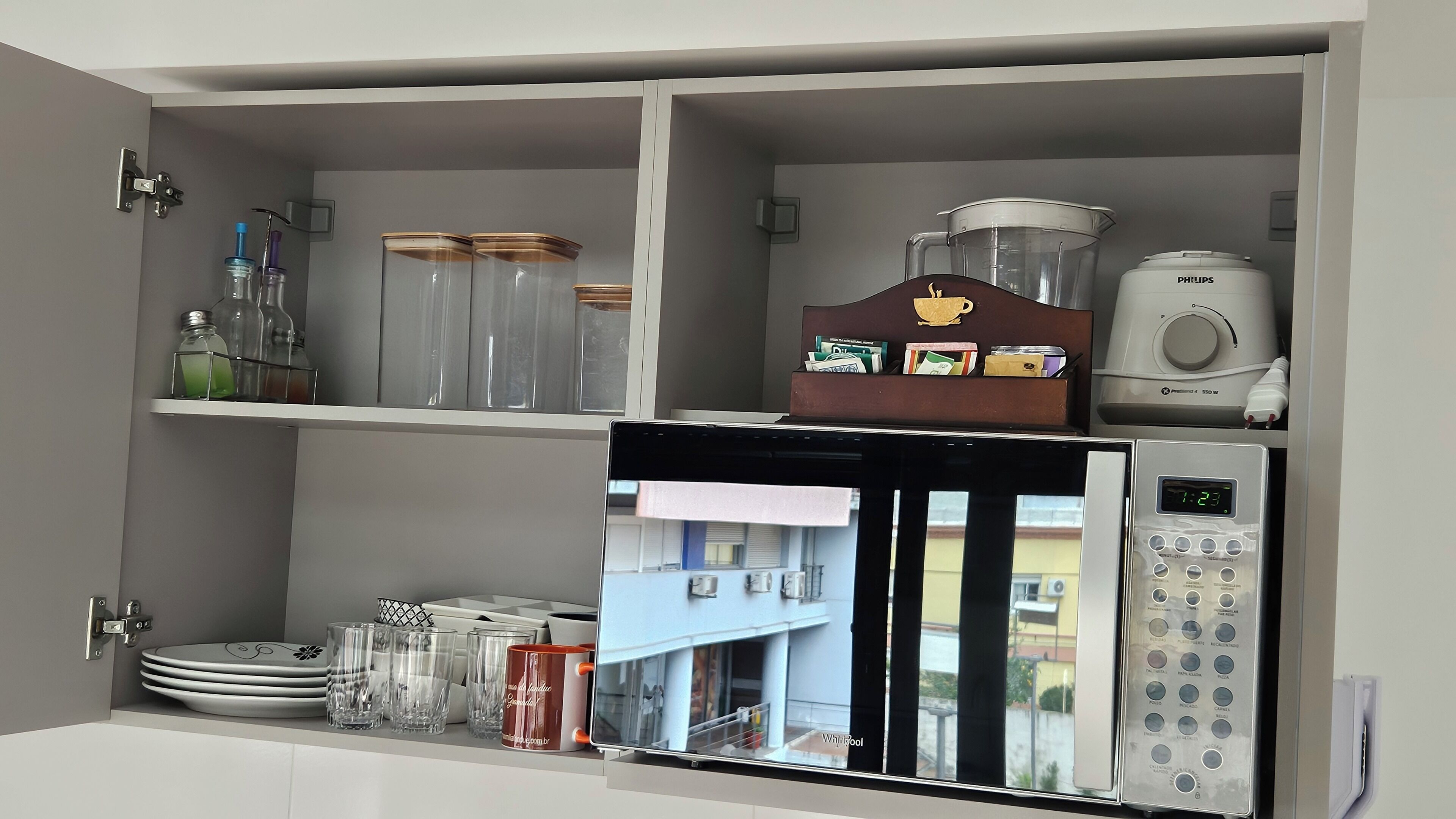 A kitchen with a microwave, a coffee maker, and a refrigerator.