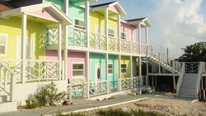 Un edifici de diverses plantes amb balcons i una escala que condueix a un moll.