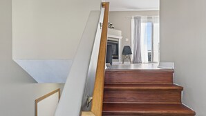 Uma escada de madeira com corrimão branco que leva a um patamar.