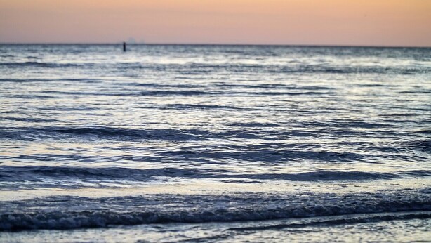 A beach with waves and a distant horizon.