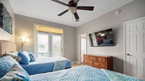 A bedroom with two beds, a ceiling fan, a TV, and a window with blinds. - Only 3 minutes walk to beach - Spacious Destin Home, Newly-renovated (Destin)