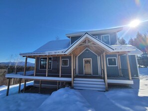 A two-story house with a covered porch and a front door. - 4 Bed Luxury White Mtn Retreat w/ Stunning Views! (Campton, NH)