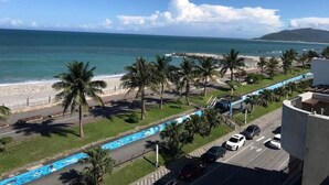A coastal road with palm trees, a beach, and a mountain in the background. - Nottingham Seaview B&B (Hualien City)