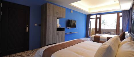 Habitación de hotel con dos camas, televisión, armario y balcón con vistas.