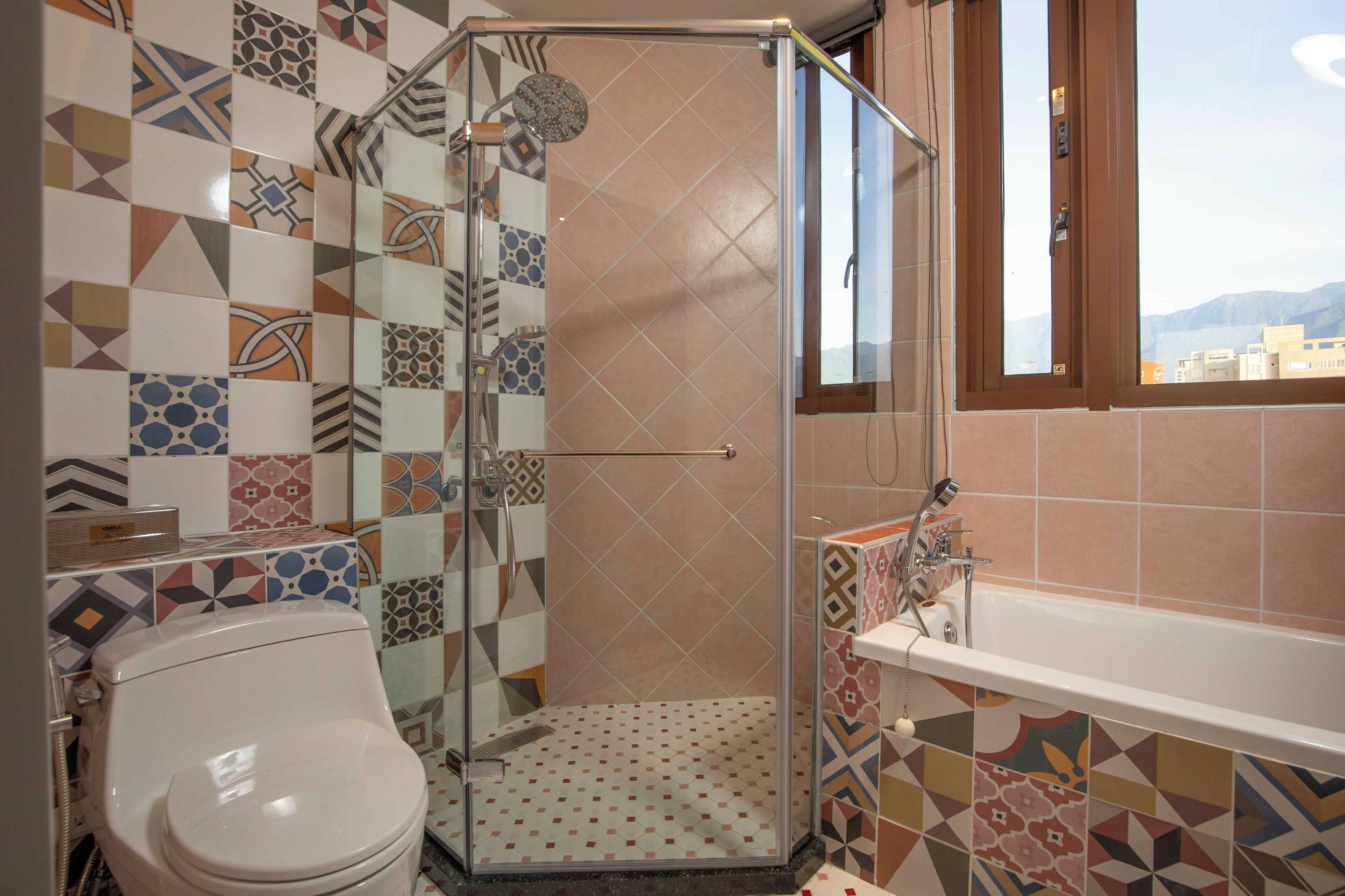 A bathroom with a shower, toilet, and bathtub.