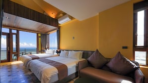 A hotel room with a large bed, a sofa, and a view of the sea. - Nottingham Seaview B&B (Hualien City)