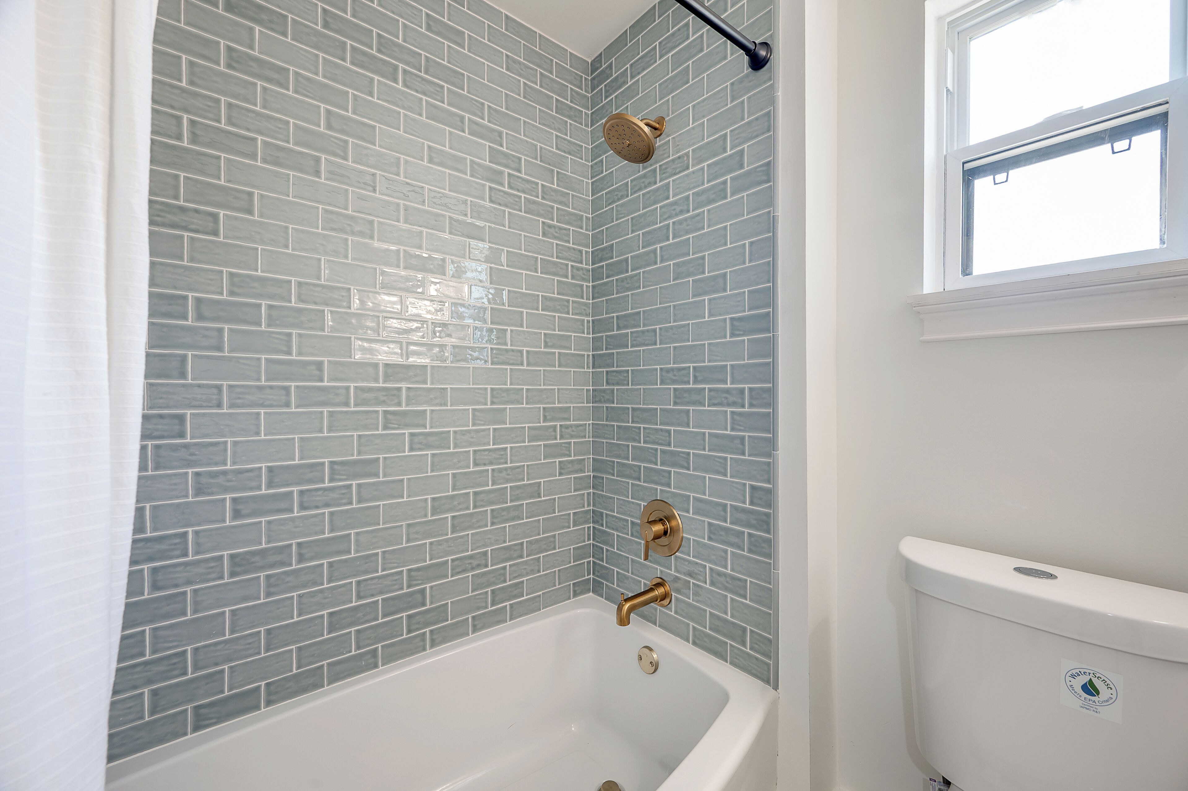 Une salle de bain avec une baignoire blanche, une douche et des toilettes.