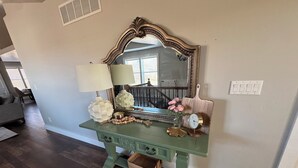 A green vanity with a mirror, a lamp, a clock, and decorative items. - Awesome 6-bedroom house with rec room, fully equipped kitchen, Near Lava (McCammon)
