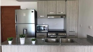 Una cucina moderna con elettrodomestici in acciaio inox, un piano di lavoro in granito e mobili in legno.