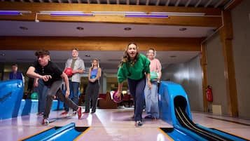 A bowling alley with wooden beams on the ceiling and a blue bowling lane.
