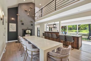 A modern kitchen with a large island, bar seating, and a view of the outdoors. - Grand River Estate IndoorPool/Swim Pond/25 Acres (Thompson)