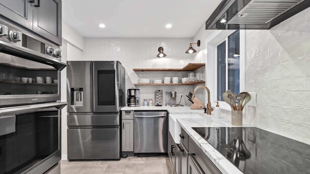 A modern kitchen with stainless steel appliances, a built-in oven, and a countertop with a sink.
