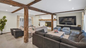 A modern living room with a large sectional sofa, a coffee table, and a flat-screen TV.