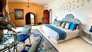 Un dormitorio con cama, una silla, un tapete y una pared decorada con estrellas.