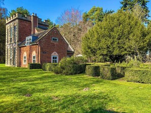 A large brick building with arched windows and a central door, surrounded by well-maintained lawns and trees. - 3 bedroom accommodation in High Ash (High Ash)