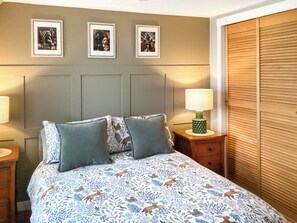 A bedroom with a bed, two pillows, a nightstand with a lamp, and three framed pictures on the wall. - 3 bedroom accommodation in Cullen, near Buckie (Buckie)