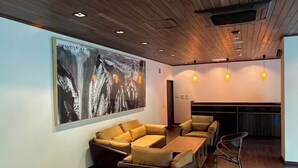 A modern lounge area with a large abstract painting, a sofa set, and a wooden ceiling. - Daido Garden Hotel Yunoyama SPA Resort (Komono)