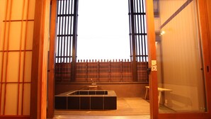 A traditional Japanese room with tatami flooring, a low wooden table, and a sliding door. - Daido Garden Hotel Yunoyama SPA Resort (Komono)