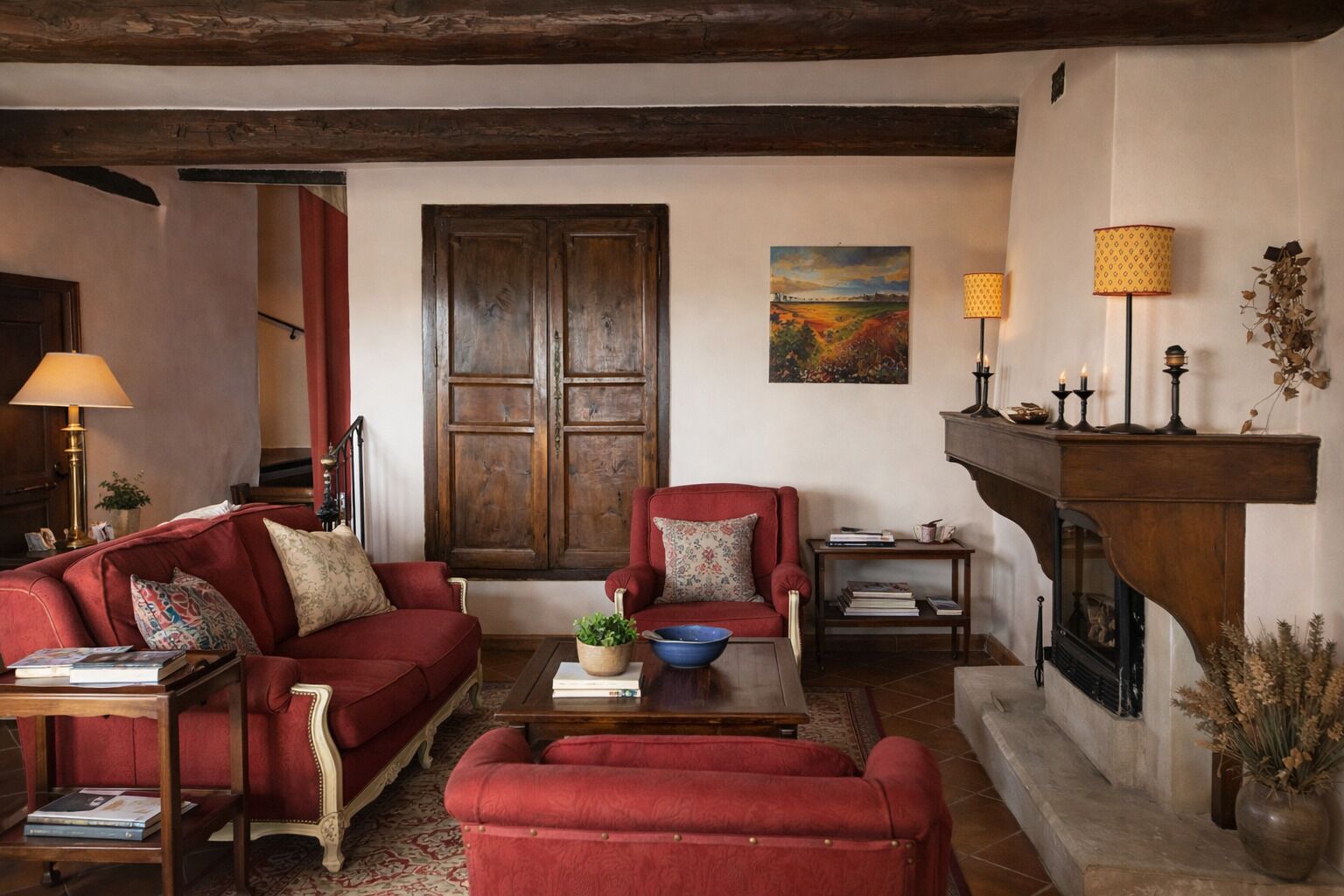 A traditional living room with a fireplace, red sofas, a coffee table, and a bookshelf.