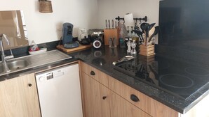 Een keuken met een vaatwasser, koffiezetapparaat, broodrooster en diverse keukengerei.