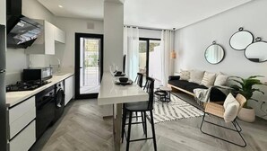 Et moderne køkken med spiseplads, en sofa og en plante.